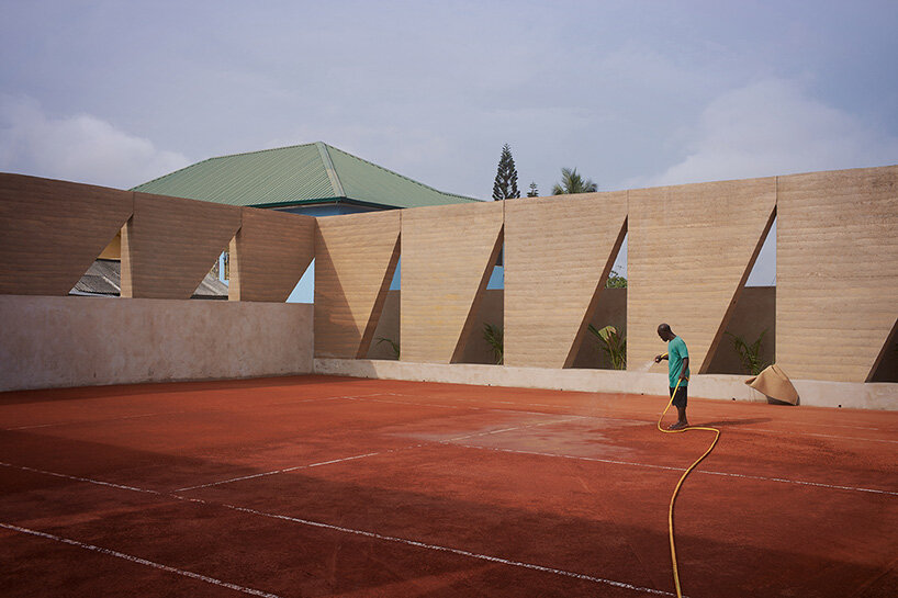 ghana’s first precast rammed earth project by deroche projects hosts community tennis court