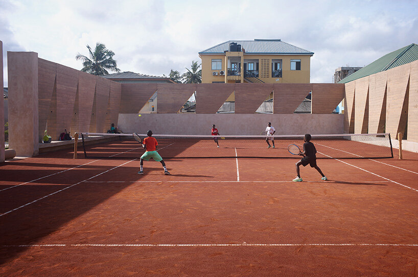 ghana’s first precast rammed earth project by deroche projects hosts community tennis court