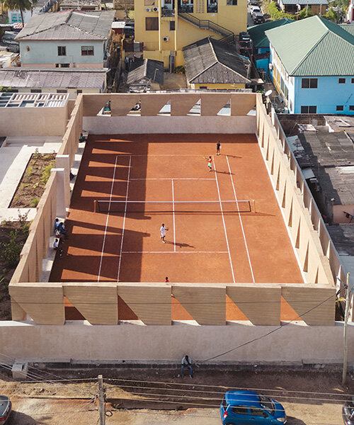 ghana's first precast rammed earth project by deroche projects hosts community tennis court