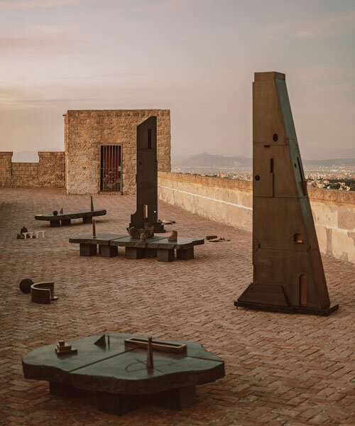 totemic sculptures compose volcanic stone landscape for site-specific installation in naples