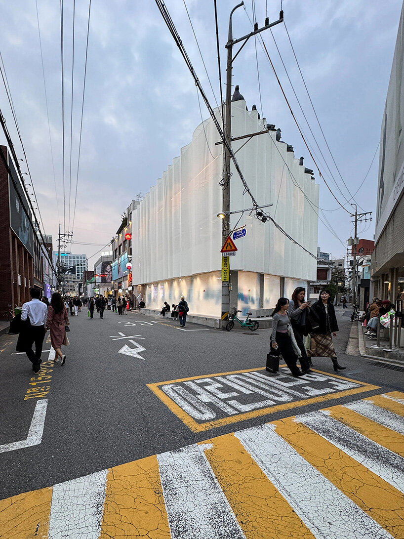Fachada translúcida en capas de la tienda H&M Seúl con silueta filtrante de silueta ondulada