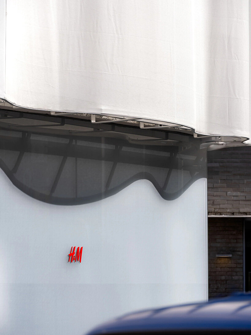 Fachada translúcida en capas de la tienda H&M Seúl con silueta filtrante de silueta ondulada