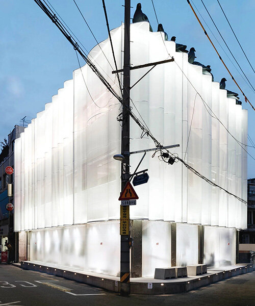 layered translucent facade with wave-like contours filters silhouettes at H&M seoul store