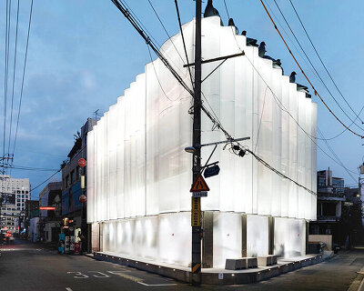 layered translucent facade with wave-like contours filters silhouettes at H&M seoul store