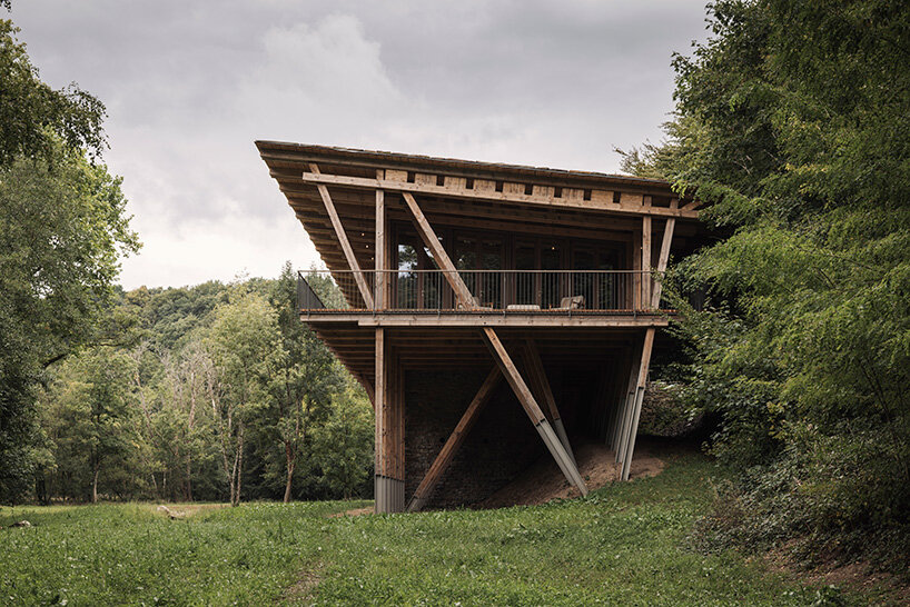 local stone and timber shape self-sufficient riverbank house by BC architects in belgium