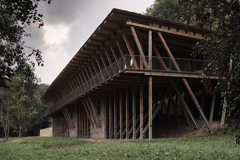 local stone and timber shape self-sufficient riverbank house by BC architects in belgium