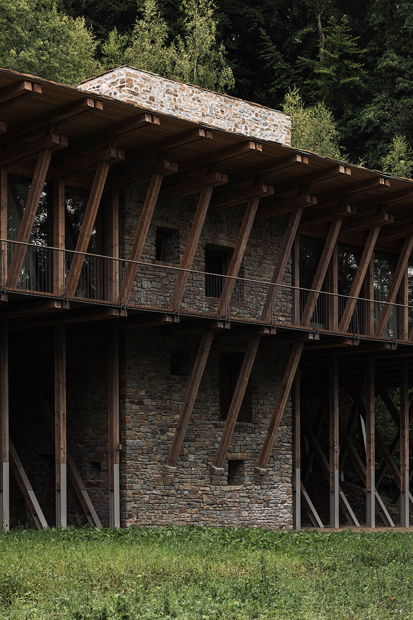 local stone and timber shape self-sufficient riverbank house by BC architects in belgium
