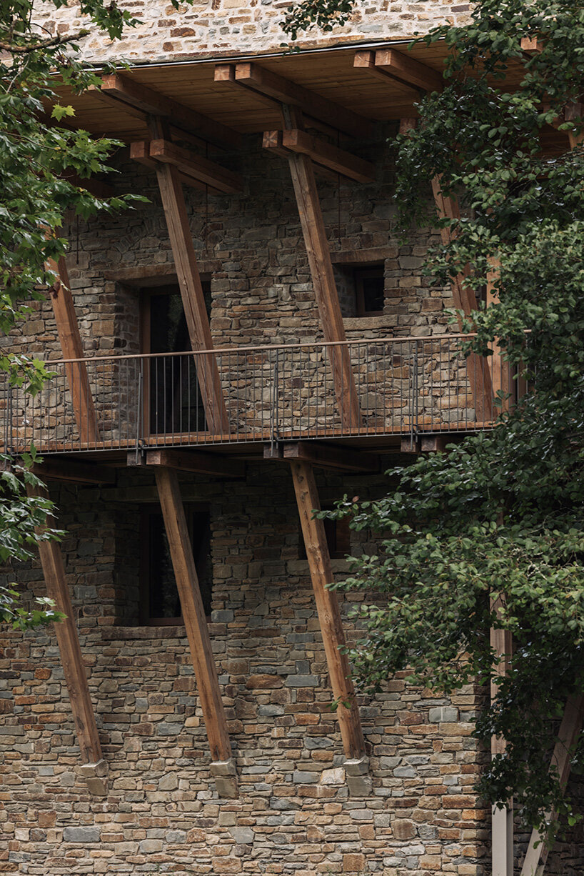 local stone and timber shape self-sufficient riverbank house by BC architects in belgium