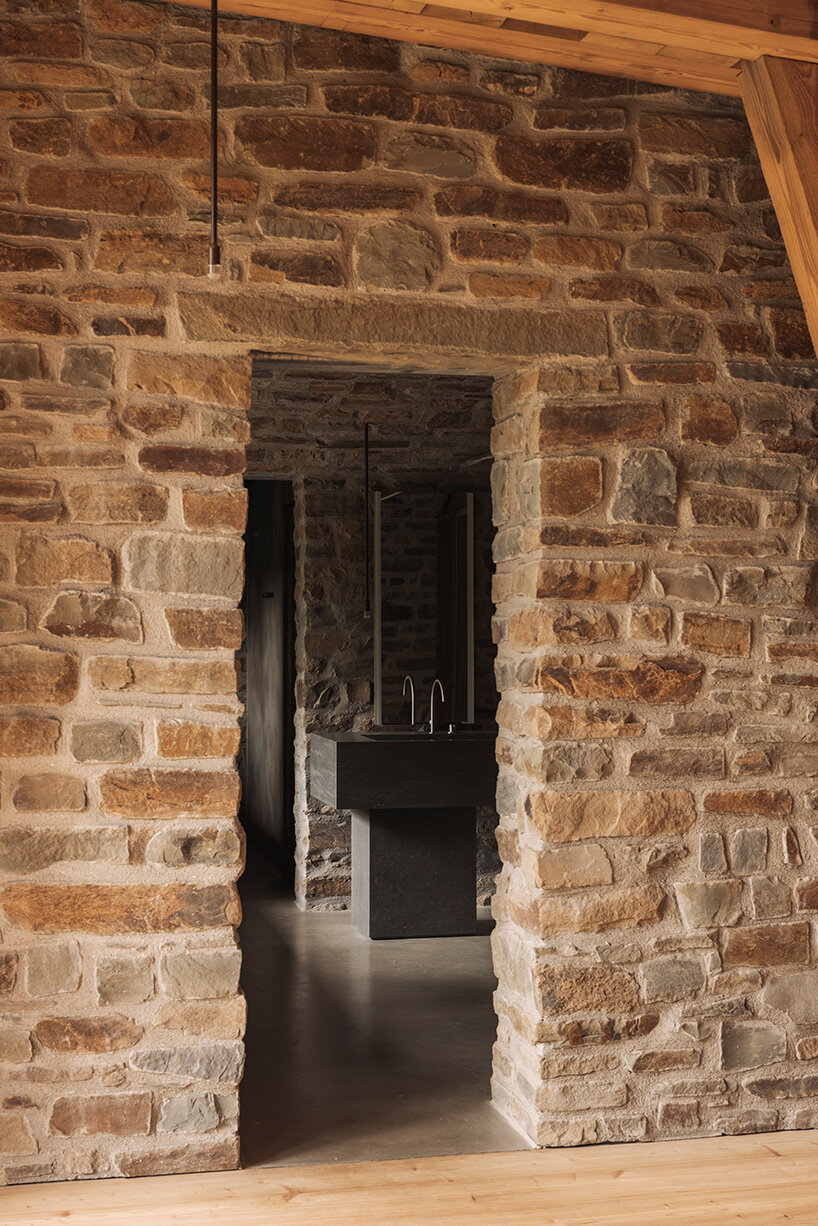 local stone and timber shape self-sufficient riverbank house by BC architects in belgium