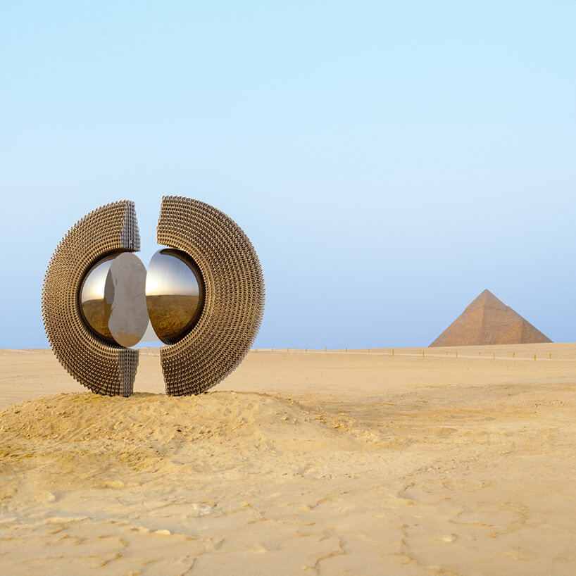 La escultura de aluminio reflectante de Mert Ege Köse se divide en el marco de las pirámides de Giza.