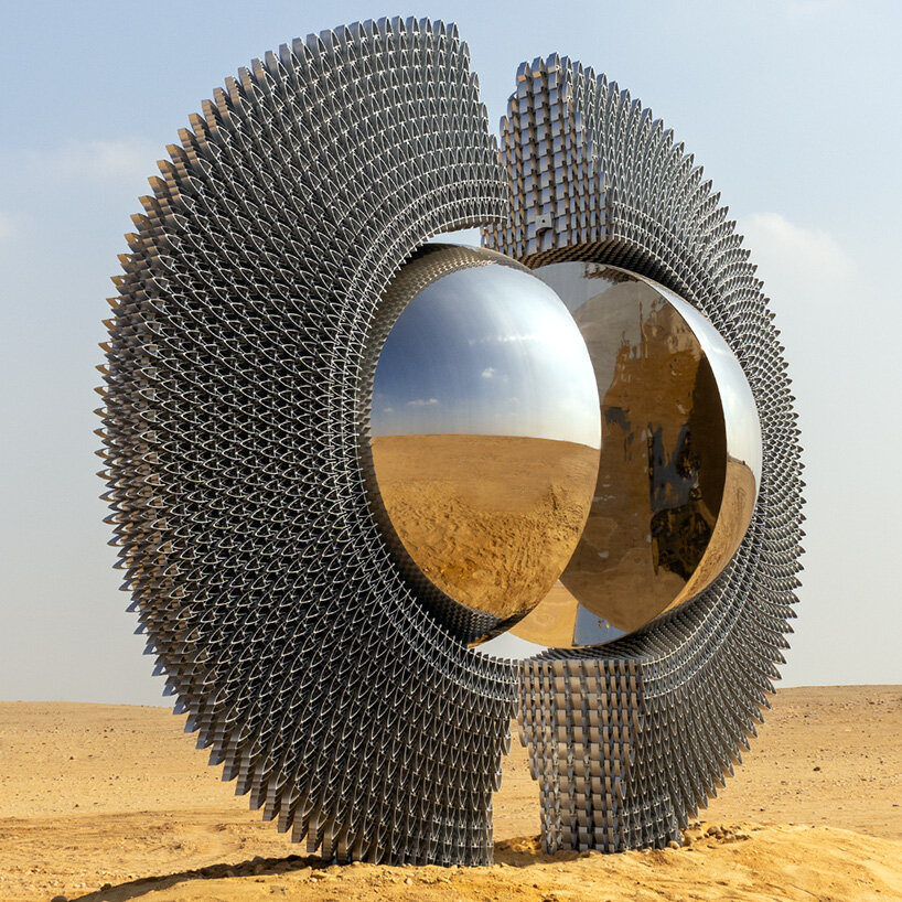 La escultura de aluminio reflectante de Mert Ege Köse se divide en el marco de las pirámides de Giza.