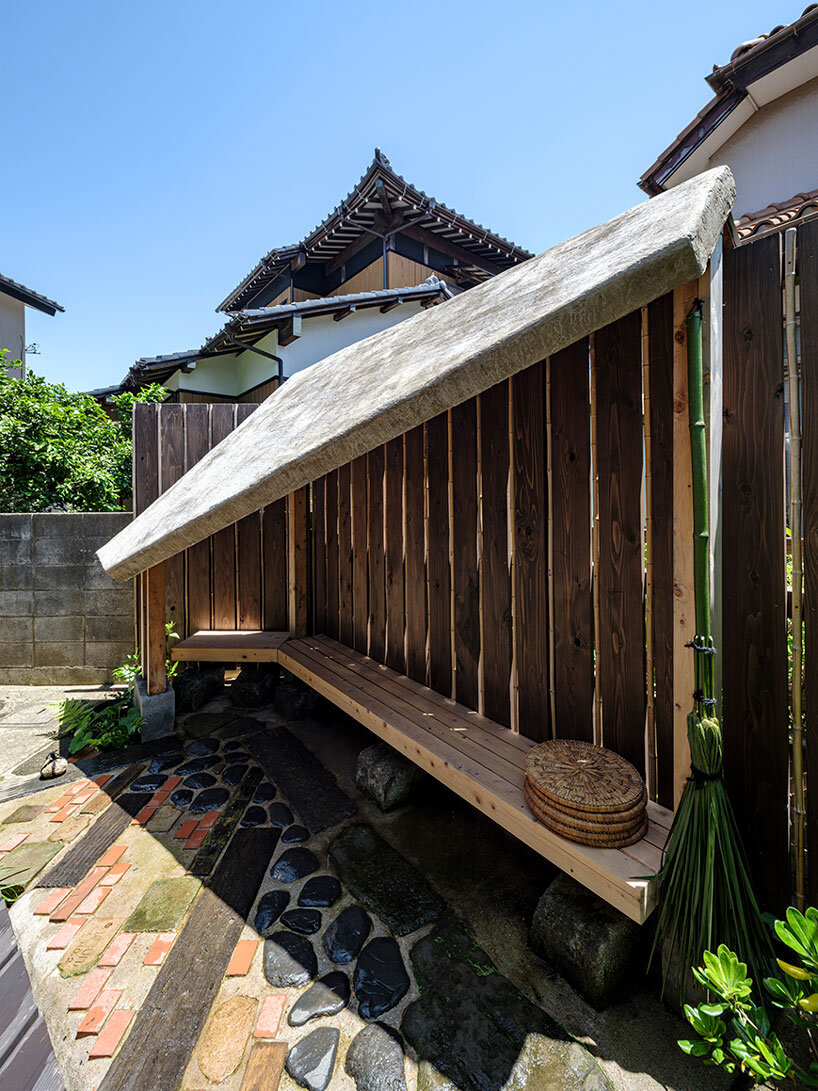 moss-covered earthen roof shields teahouse’s waiting area in japan