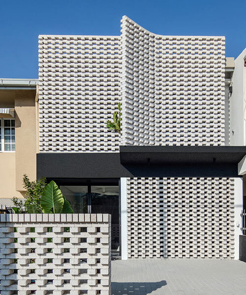porous white brickwork facade enfolds renovated 1980s terrace house in kuala lumpur