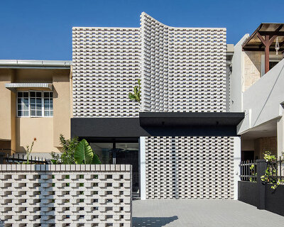 porous white brickwork facade enfolds renovated 1980s terrace house in kuala lumpur