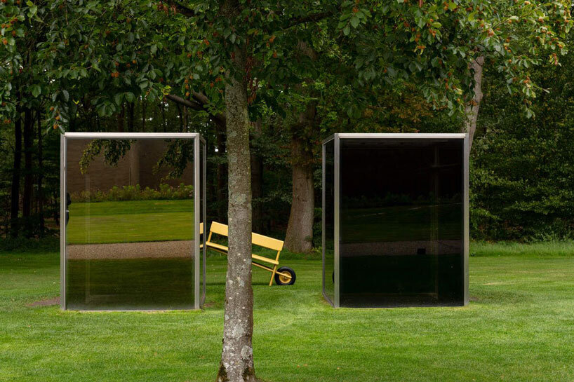 Forma redonda de aluminio con base de rueda de capa amarilla ocre en el jardín de un museo holandés