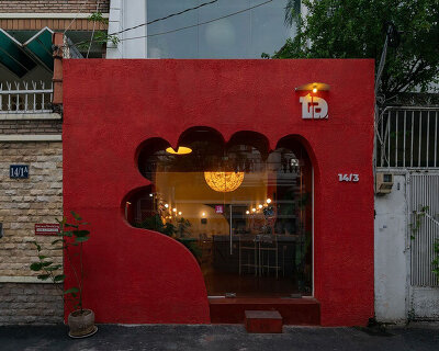 café’s red facade carves welcoming hand-shaped entrance in vietnam