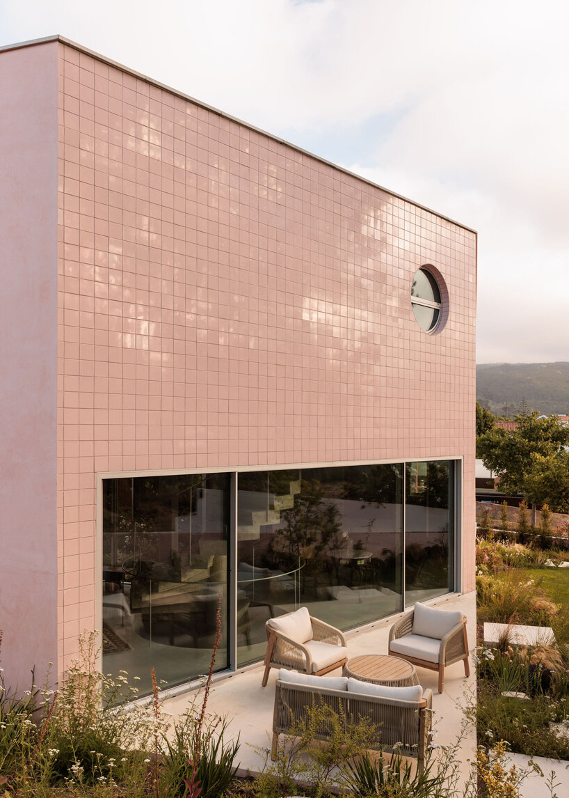 atelier RUA's light pink house contrasts with surrounding greenery in portugal