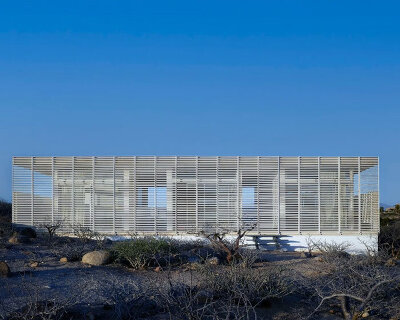 white louvers craft perforated facade filtering daylight within casa nada’s interiors in mexico