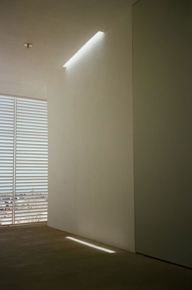 white louvers craft perforated facade filtering daylight within casa nada’s interiors in mexico