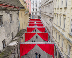 red and white curtains transform czech historic center’s pathways into christmas installation