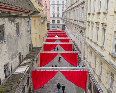 red and white curtains transform czech historic center’s pathways into christmas installation