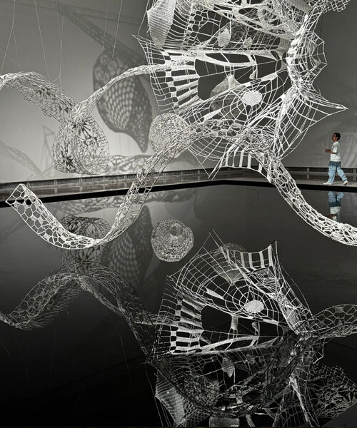 crocheted zodiac animal installations by choi+shine suspend above dark body of water