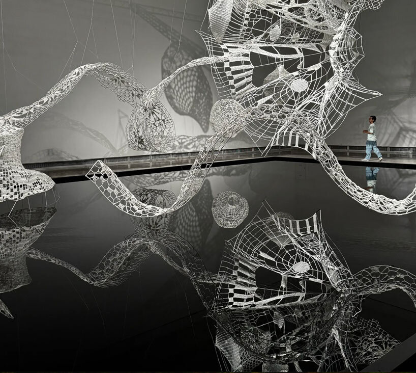 crocheted zodiac animal installations by choi+shine suspend above dark body of water