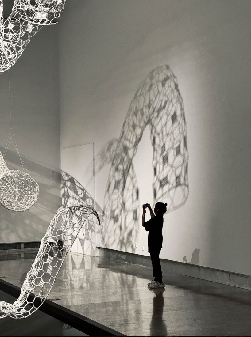 crocheted zodiac animal installations by choi+shine suspend above dark body of water