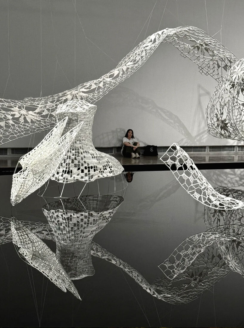 crocheted zodiac animal installations by choi+shine suspend above dark body of water
