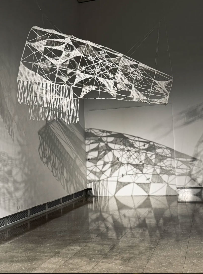 crocheted zodiac animal installations by choi+shine suspend above dark body of water