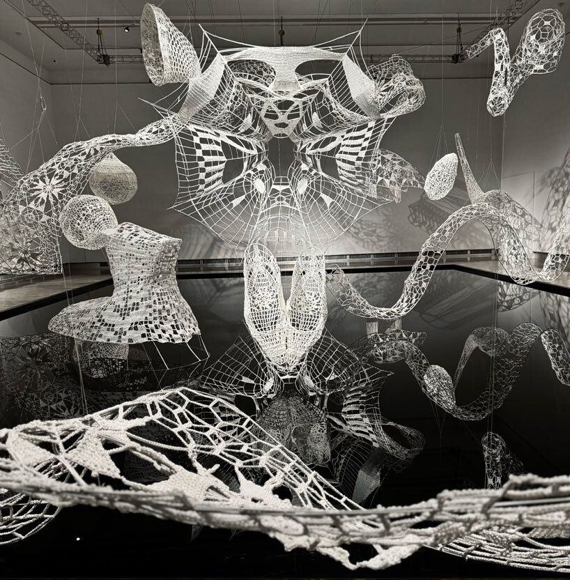 crocheted zodiac animal installations by choi+shine suspend above dark body of water