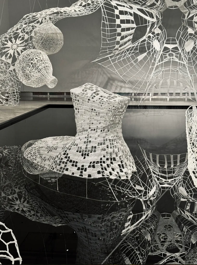 crocheted zodiac animal installations by choi+shine suspend above dark body of water