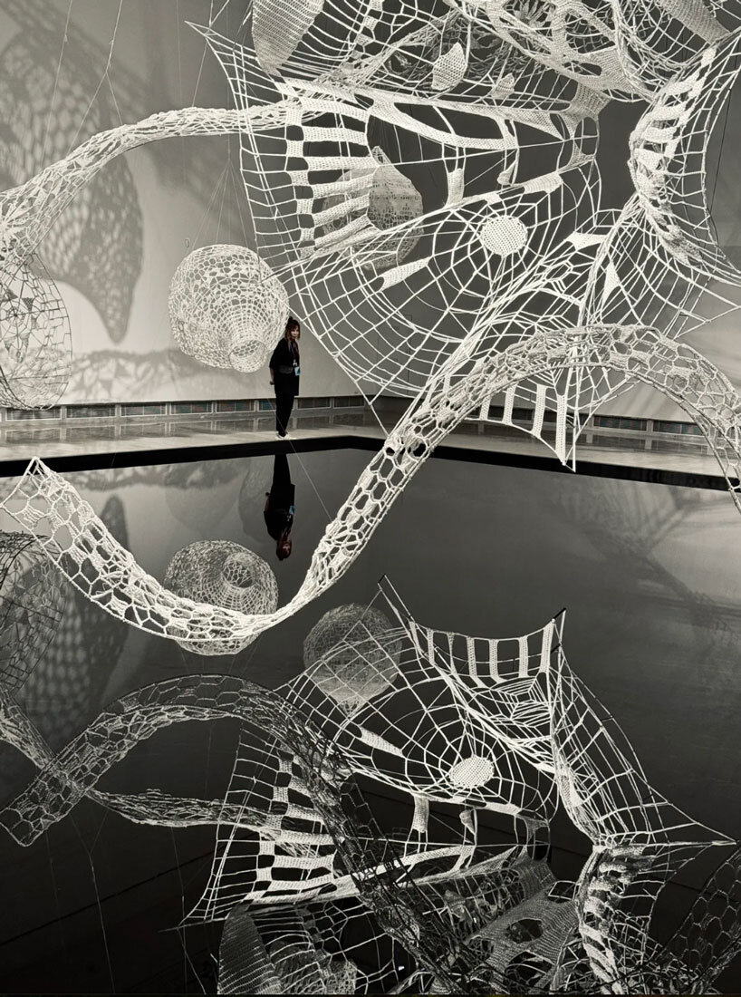 crocheted zodiac animal installations by choi+shine suspend above dark body of water