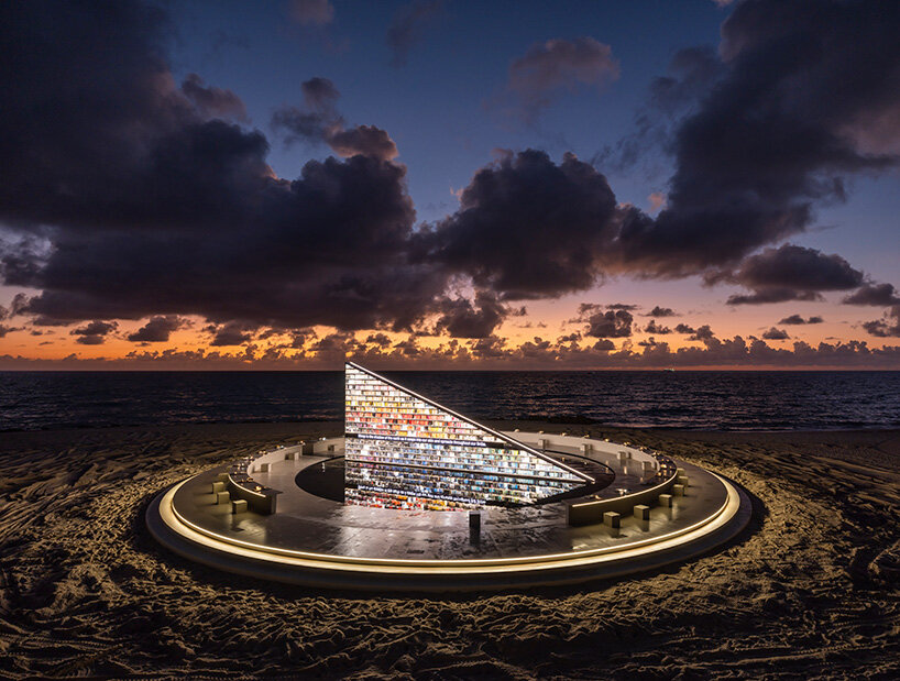 es devlin's triangular bookshelf rotates within a mirrored pool for miami art week 2025