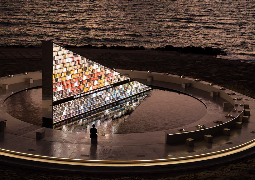 es devlin's triangular bookshelf rotates within a mirrored pool for miami art week 2025