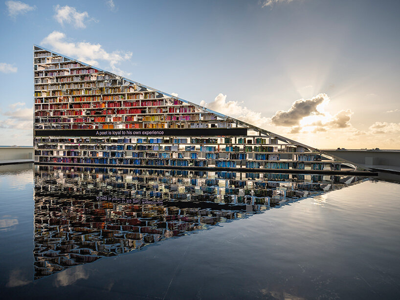 estantería triangular diseñada por es devlin para la semana del arte de miami 2025 gira dentro de una piscina con espejos