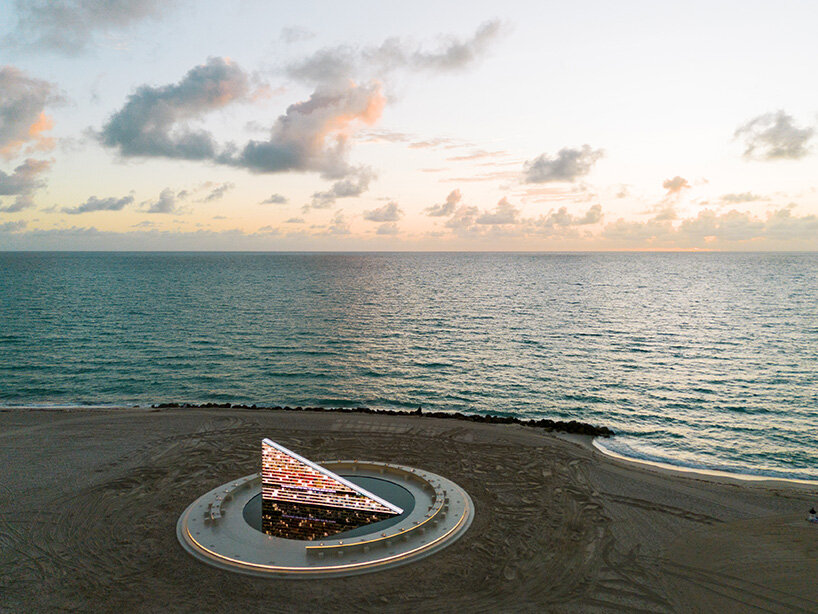 estantería triangular diseñada por es devlin para la semana del arte de miami 2025 gira dentro de una piscina con espejos