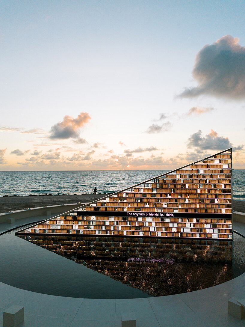 estantería triangular diseñada por es devlin para la semana del arte de miami 2025 gira dentro de una piscina con espejos
