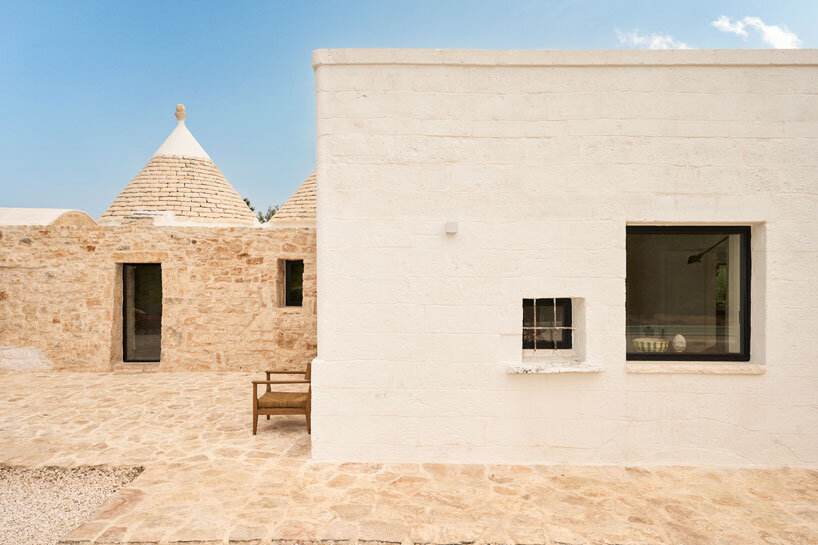 Tres tradicionales edificios trulli con cúpulas de piedra se combinan en una casa contemporánea diseñada por el estudio italiano 8.