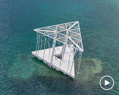 triangular wooden pavilion floats on reused plastic gallons along croatia’s coasts