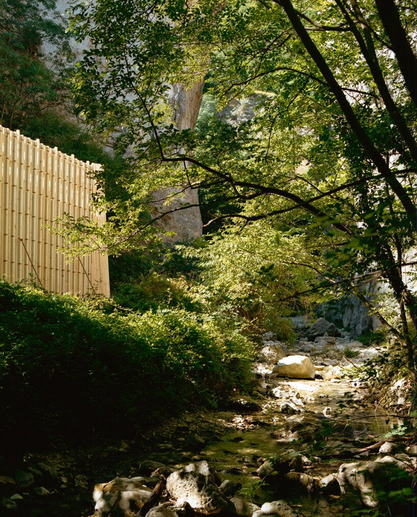 river chapel pavilion lands as an overturned timber vessel in the italian mountains