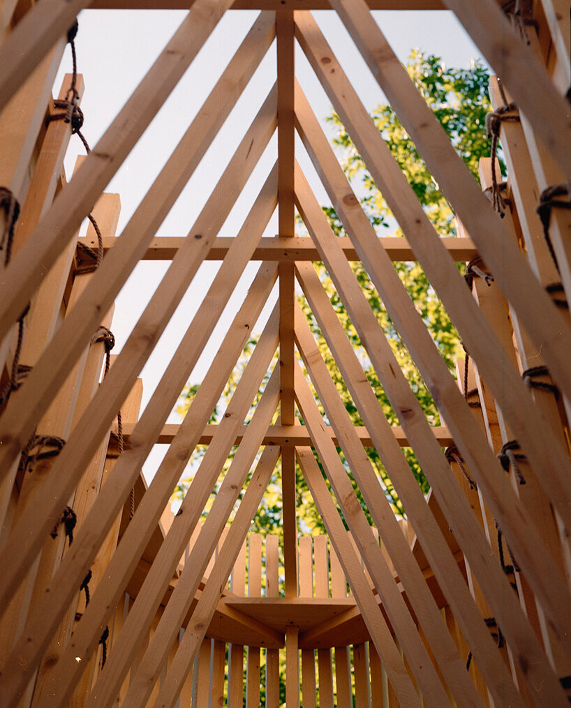 river chapel pavilion lands as an overturned timber vessel in the italian mountains