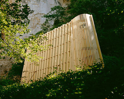 river chapel pavilion lands as an overturned timber vessel in the italian mountains