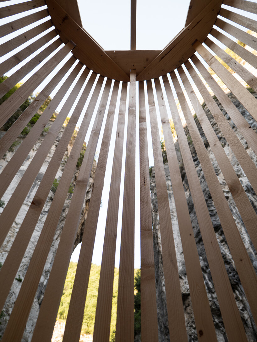 river chapel pavilion lands as an overturned timber vessel in the italian mountains