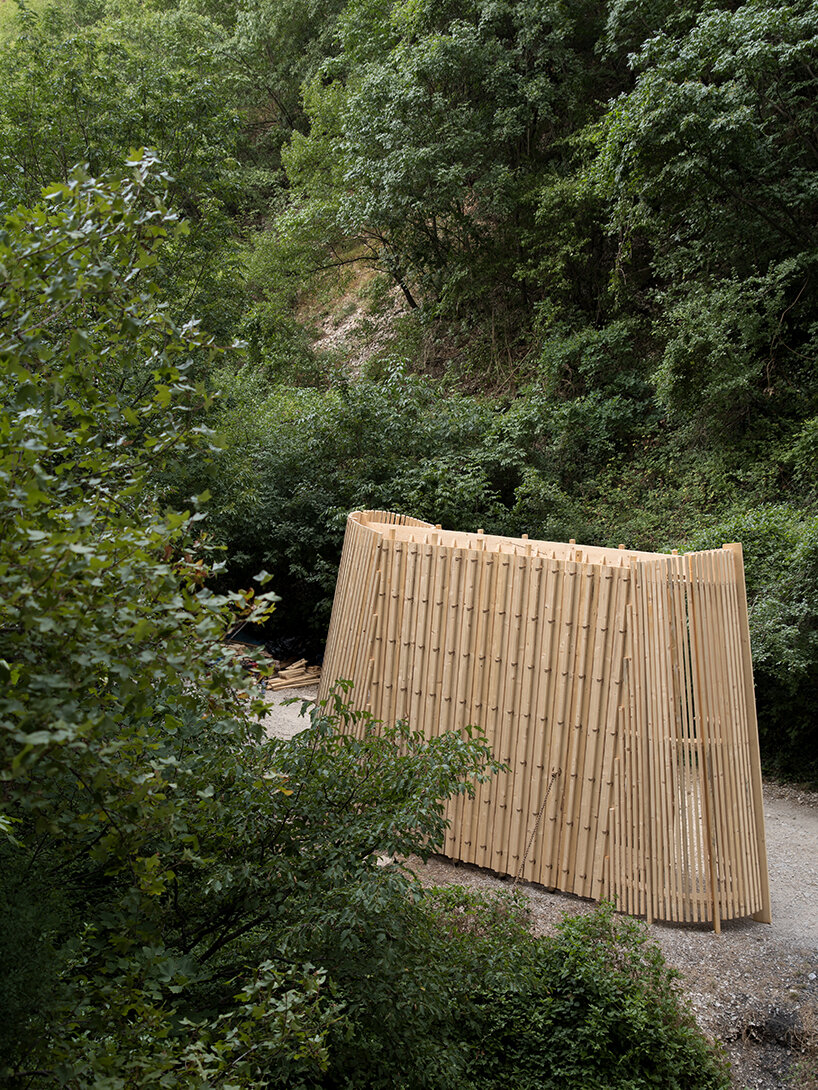 river chapel pavilion lands as an overturned timber vessel in the italian mountains