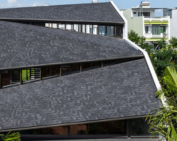 tent house expands under overlapping angular roof planes in vietnam