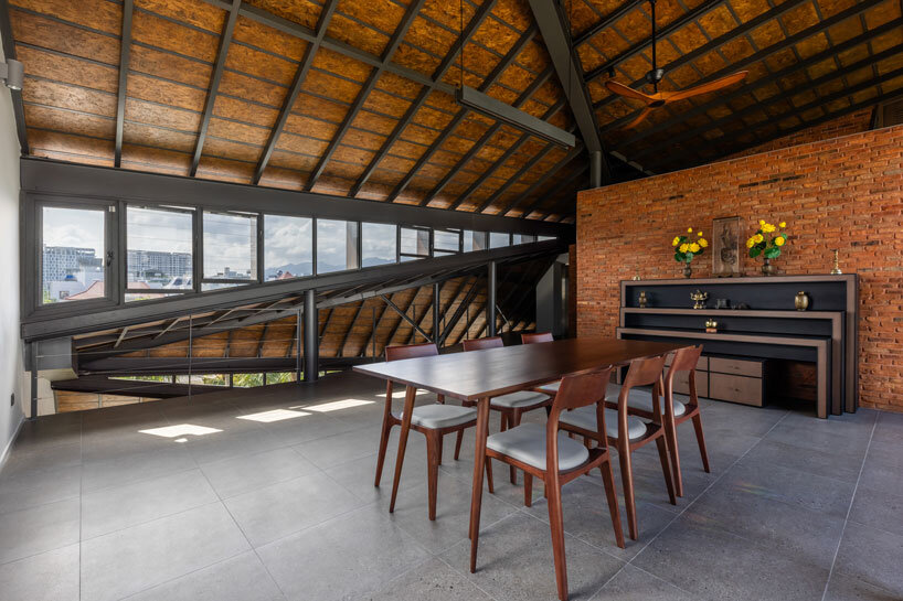 tent house expands under overlapping angular roof planes in vietnam