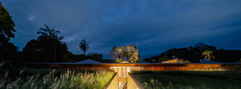 TETRO's lakeside residence in brazil vanishes into the horizon beneath triangular timber roof