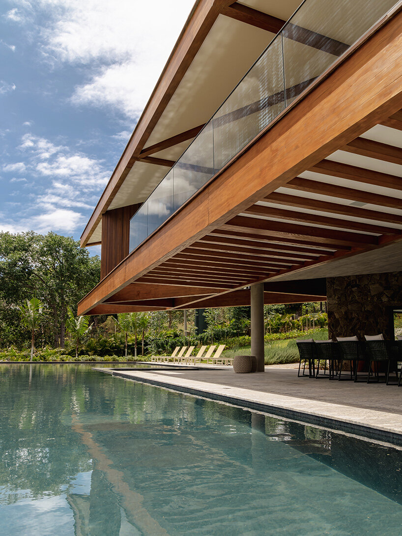 TETRO's lakeside residence in brazil vanishes into the horizon beneath triangular timber roof
