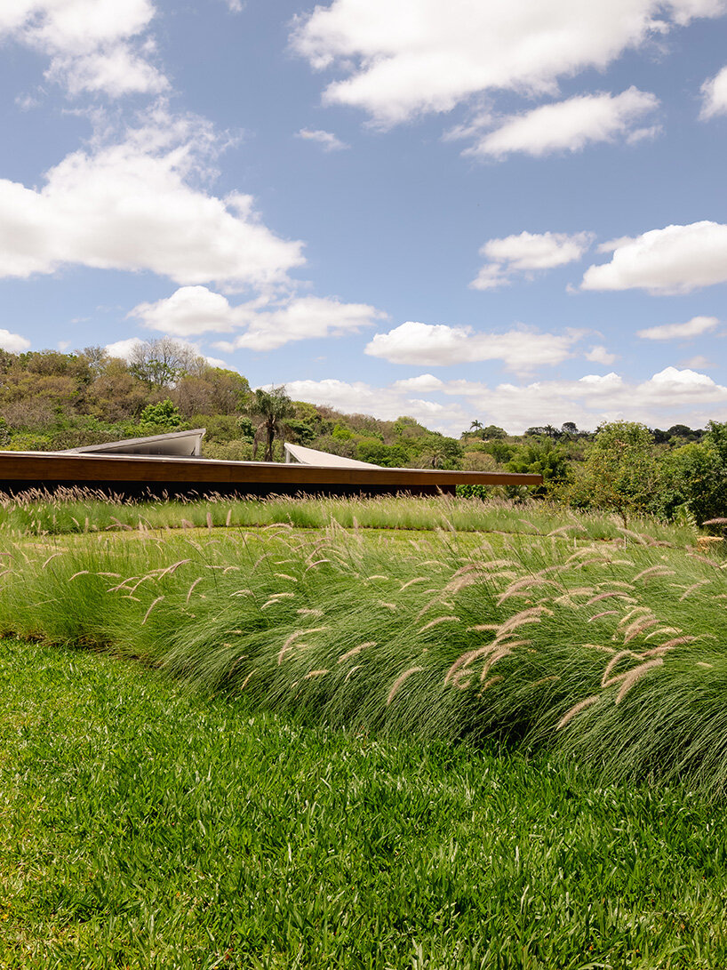 TETRO's lakeside residence in brazil vanishes into the horizon beneath triangular timber roof